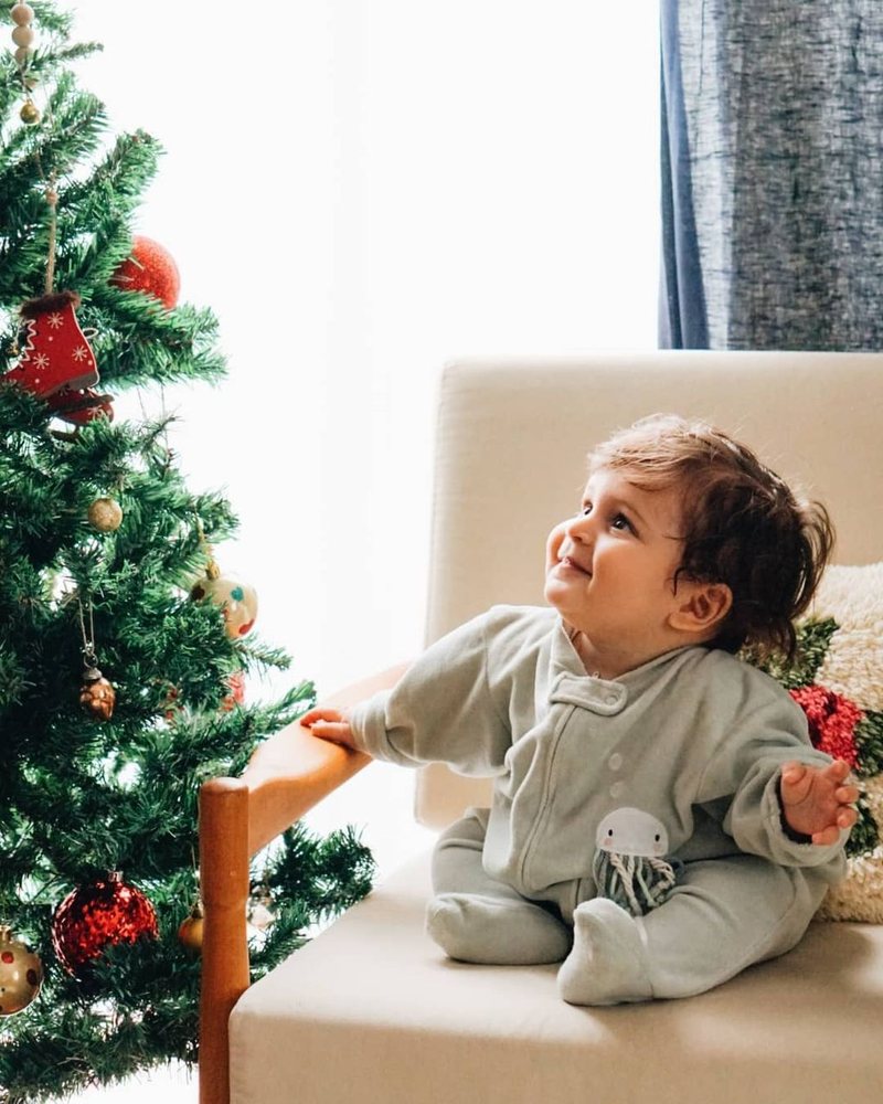 Dünya as a baby, looking up at a Christmas tree